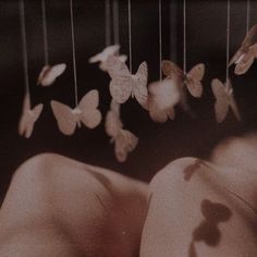 a woman's back with butterflies hanging from the strings in front of her head