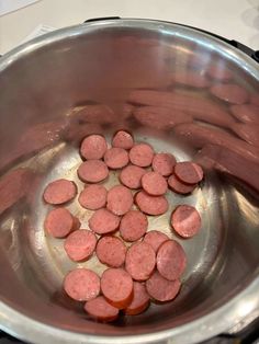 some sausages are cooking in a pot on the stove