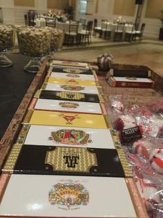 several candy bars are lined up on a long table in a banquet hall with tables and chairs