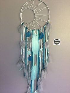 a blue and white dream catcher hanging on the wall