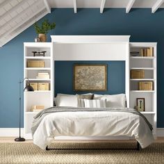 a bedroom with blue walls, white furniture and bookshelves on the shelves above the bed