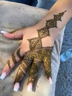 a woman's hand with henna tattoos on it