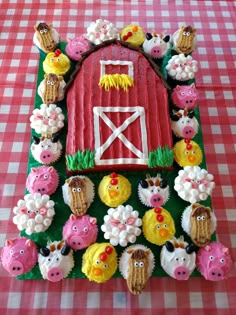 cupcakes are arranged in the shape of a barn and farm animals