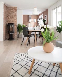 a living room filled with furniture and a fire place next to a dining room table