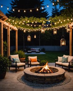 an outdoor fire pit surrounded by chairs and lights