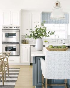 a kitchen with white cabinets and an island in front of a stove top oven next to a dining room table