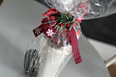 a plastic bag filled with candy canes on top of a white counter next to a knife