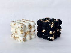 two different types of black and white objects on a white surface, one with gold sprinkles