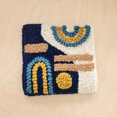 a crocheted placemat with a blue, yellow and white design on it