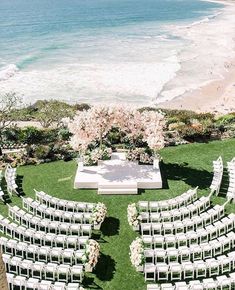 an aerial view of a wedding ceremony set up on the lawn overlooking the ocean and beach