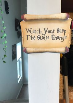 a sign that says watch your step, the stair change is hanging on a wall