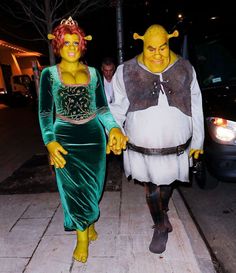 two people in costumes are walking down the street