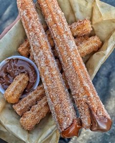 two churros with chocolate sauce and dipping sauce