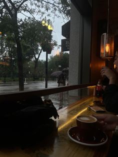 a woman sitting at a bar with an umbrella in the background and a cup of coffee next to her