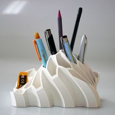 a pen holder with pens and pencils in it