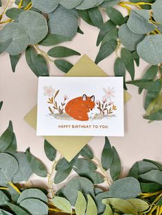 a card with a fox on it surrounded by leaves and greenery that says happy birthday to you