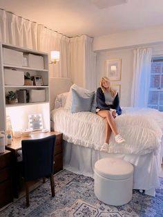 a woman sitting on top of a bed in a bedroom