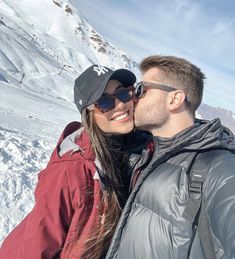 a man and woman are standing in the snow