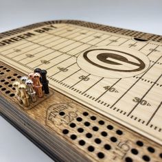 three wooden pegs are sitting on top of a board with numbers and figures in it