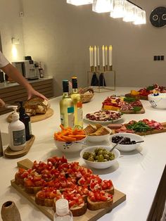 a table filled with different types of food and bottles of wine on top of it