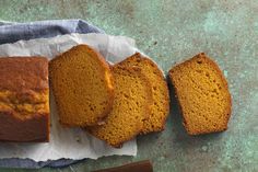 three slices of pumpkin bread sitting on top of a piece of paper next to a knife