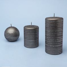 three candles sitting next to each other on a blue surface