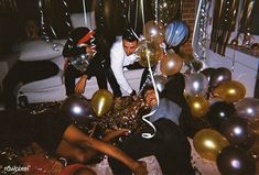 a group of people sitting on the floor with balloons and streamers