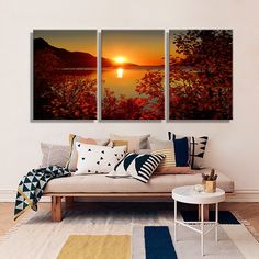 three paintings on the wall of a living room with a couch and coffee table in front of it