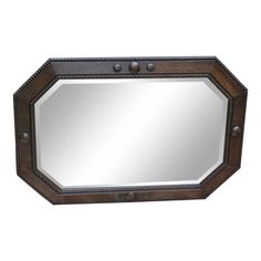 a mirror that is sitting on top of a wall with metal studs and wood trimming