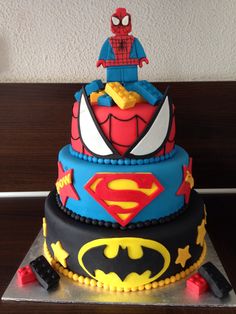 a three tiered birthday cake decorated with legos and batman characters on it's sides