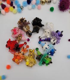 many small toy animals are laying on the floor with pom - poms around them