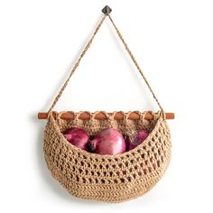 a basket filled with apples hanging on a wall