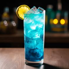 a tall glass filled with blue liquid and ice