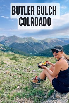 a woman sitting on top of a grass covered hillside with the words butter guch colorado