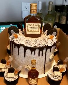 a cake decorated with cupcakes, cookies and a bottle of henness syrup