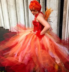 a woman dressed in an orange and red costume