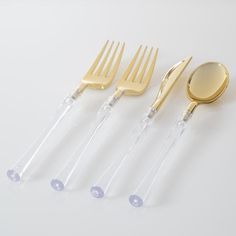 four forks and two spoons are sitting next to each other on a white surface