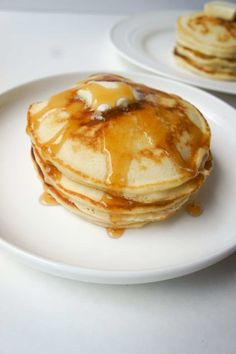 pancakes on a plate with syrup and butter drizzled all over the top