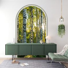 a living room with an arched window and green furniture in front of the tree - lined wall