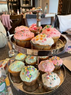 three tiered trays filled with cupcakes on top of a table