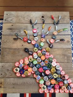 a wooden table topped with lots of bottle caps and a tree made out of bottles