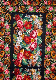 a black and red rug with flowers on it