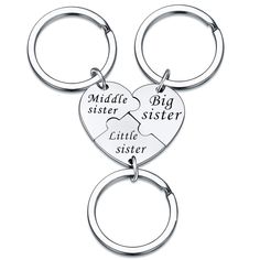 two heart shaped key chains with the words, middle sister and big sister on them