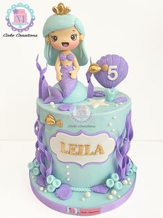 a blue and purple cake with a little mermaid on top