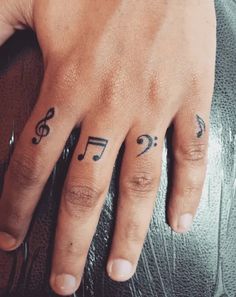 a person's hand with musical notes tattooed on it