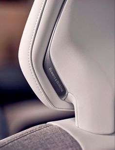 the interior of a car with white leather and stitching on it's armrests