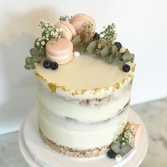 a white cake topped with macaroons and blueberries