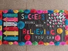 a bulletin board with colorful paper umbrellas and words on it that read success begins with believing you can