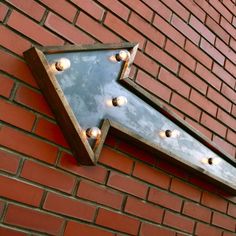 a metal arrow on the side of a brick building