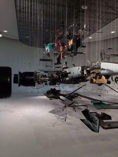 an art installation with multiple objects suspended from the ceiling